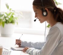 Side-of-a-woman-wearing-headset-with-microphone-looking-at-laptop-screen